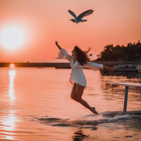 Una golondrina volando alto  en un atardecer en tonos rosa y naranja con mar y una golondrina volando alto